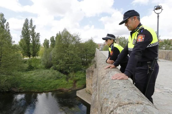 Los policías locales Piedad Sánchez y José Manuel Caldera, en el lugar exacto del Puente Nuevo donde salvaron la mujer. :: andy solé