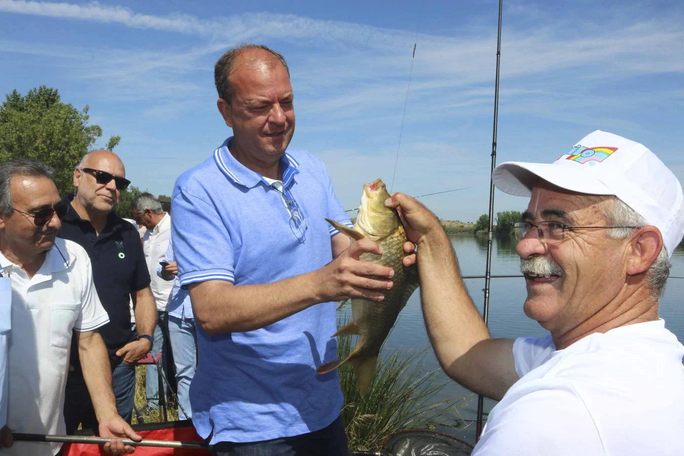 El presidente y candidato a la reelección agarra la carpa que pescó con la caña de Julián Alfonso González, que posa sonriente. :: j. m. romero