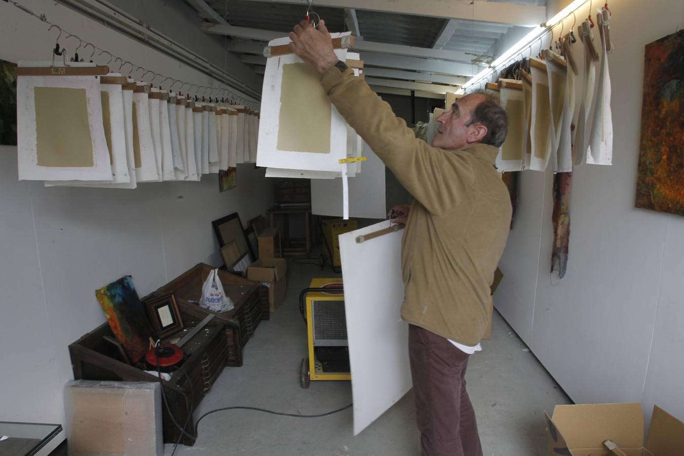 Juan Barbé cuelga papeles recién elaborados en el secadero situado junto a su taller. :: mario rojas