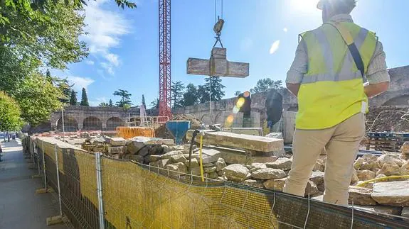 Los operarios desmontando la antigua Cruz de los Caídos de mármol