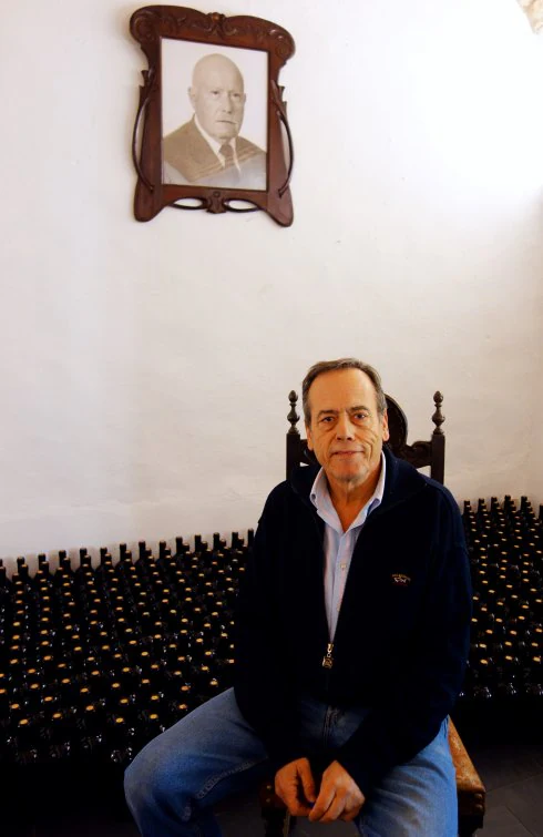 León, el bodeguero, sus botellas y un retrato de su padre. :: E.R.