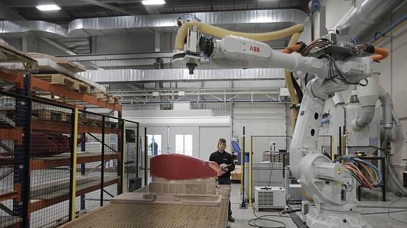 Un técnico de Sofitec controla un robot durante el proceso de recanteado en piezas de composites.