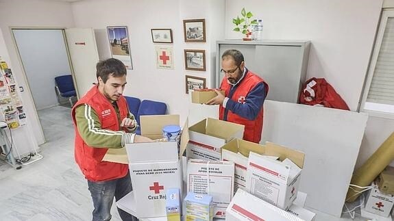 Voluntarios de Cruz Roja llenan cajas con alimentos
