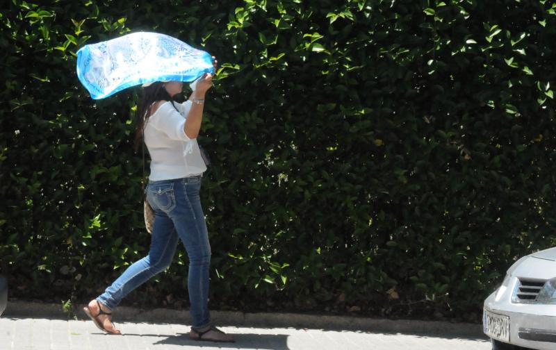 Una joven se protege del calor con un pañuelo, esta mañana en Mérida.::