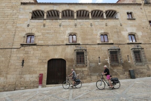Dos ciclistas pasan ante el Palacio del Doctor Trujillo, una de las antiguas sedes de los juzgados donde quiere abrir la UCAV. :: andy solé