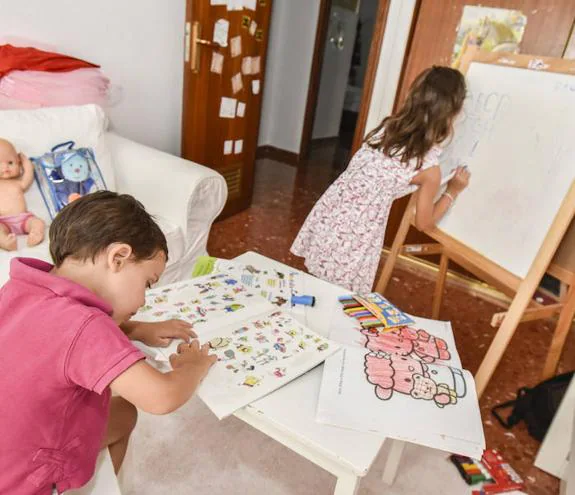 Dos niños  estudian en su  casa.  :: j. v. arnelas
