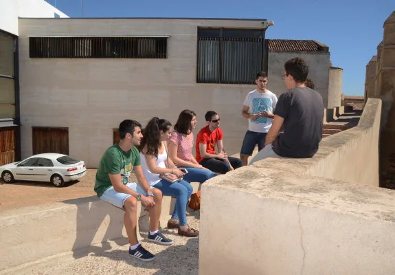 Alumnos de Comunicación sentados en la muralla ayer frente a lo que queda del Cubo . :: c. moreno