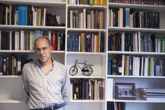 Eugenio Fuentes, ante la biblioteca de su domicilio en Cáceres. :: jorge rey