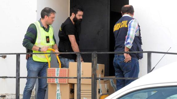 Agentes de la Guardia Civil retiran documentación de la sede de UPA en Mérida. :: 