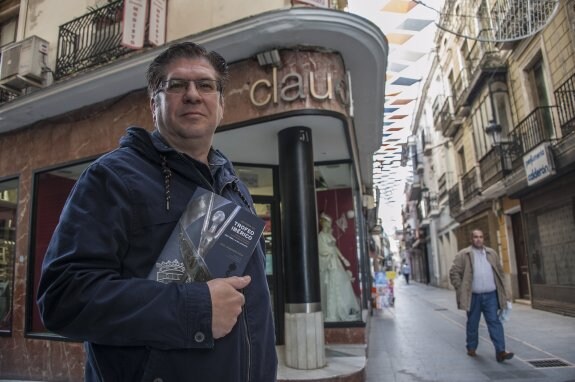 Raúl Hernández posa con su libro delante del escaparate donde se exhibía el Trofeo Ibérico. :: PAKOPÍ