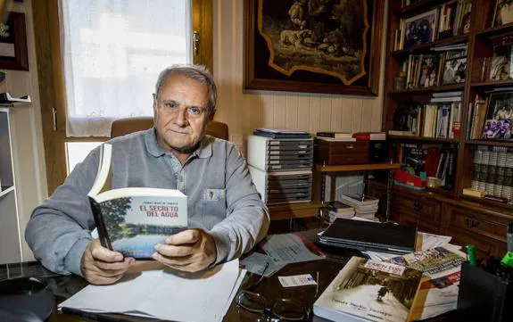 Tomás Martín Tamayo en su despacho con su última novela, 'El secreto del agua'. :: J. V. Arnelas