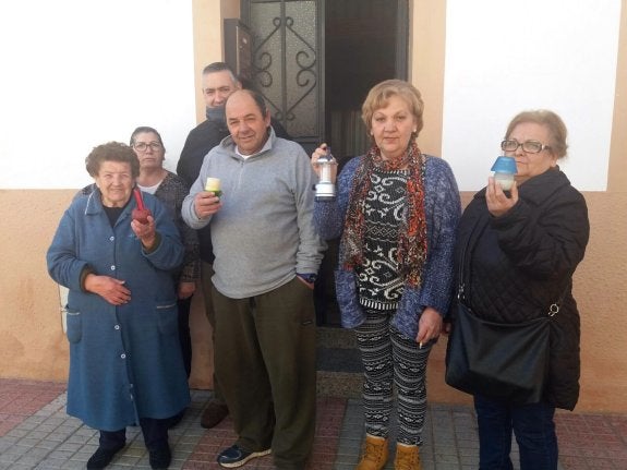 Varios de los vecinos afectados por los cortes de luz, con las velas y los farolillos para alumbrarse. :: hoy