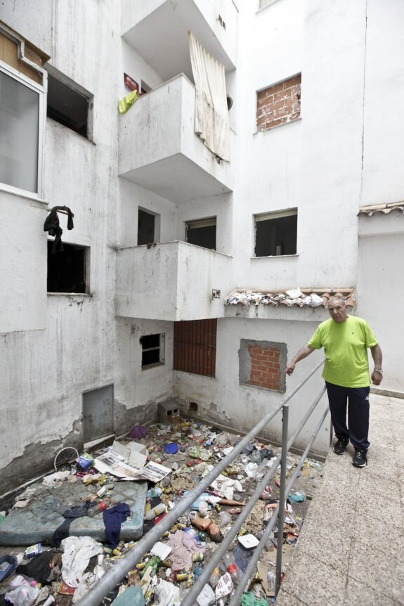 Manuel Borrella, presidente del blque 1, señala la basura que tiran al patio los vecios del bloque 2. :: L. C.