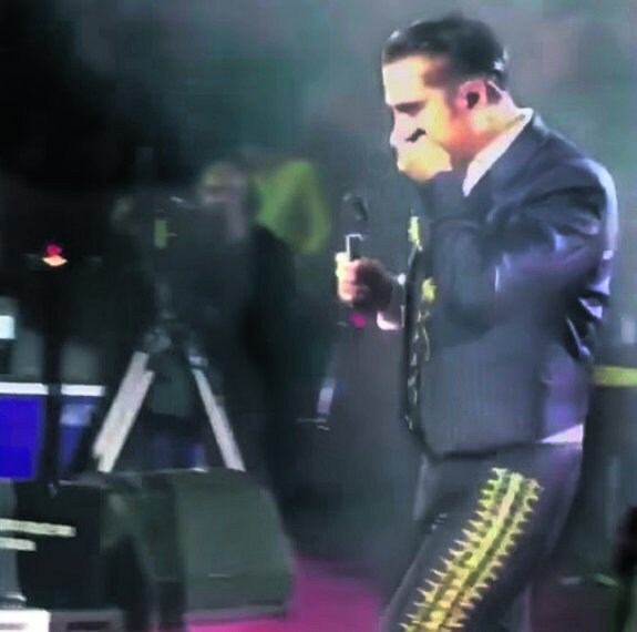Alejandro Fernández, a punto de vomitar sobre el escenario, tras beberse un tequila. :: R. C.