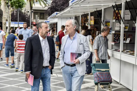 José Luis Garci y Luis Alberto de Cuenca recorren la feria del Libro de Badajoz. :: arnelas