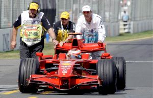 Varios comisarios de carrera empujan el monoplaza del finlandés Kimi Raikkonen tras pararse su coche en la línea de boxes en el GP de Australia. / EFE