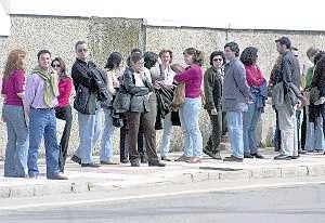 Funcionarios de la Junta de Extremadura esperando el autobús que les llevará de Mérida a Badajoz. ::                             HOY