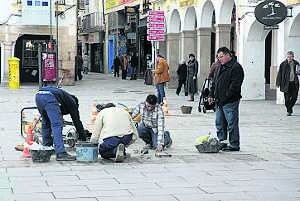 Varios trabajadores sustituyen baldosas de la plaza de España de Mérida. ::
BRÍGIDO