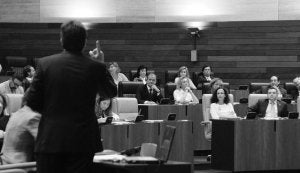 Fernández Vara de espaldas, y al fondo sentado escuchándole José Antonio Monago. ::                             BRÍGIDO