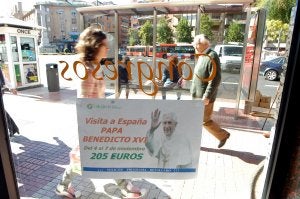 Cartel promocional del viaje del Papa a España colgado en una agencia de viajes de la capital cacereña . ::                             JORGE REY