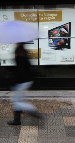 Una mujer pasa por delante de una campaña bancaria. ::
I. PÉREZ