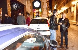 Varios clientes de un bar de copas del centro fuman en la puerta. ::                             HOY