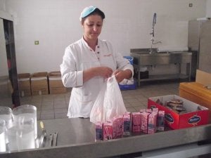 La encargada del comedor reparte las bolsas de picnic. ::                             G. C.