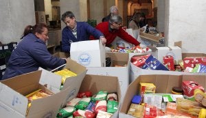 Voluntarios del Banco de Alimentos trabajando ayer por la noche en la clasificación de comida en el silo de Aldea Moret. ::                             MARISA NÚÑEZ