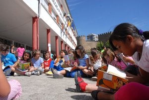 Alumnos de Primaria en una sesión de lectura en el patio de un colegio placentino. ::                             PALMA