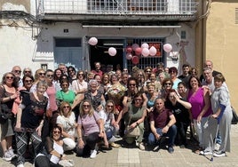 Reme Serrano con su ramo de flores rodeada por sus clientela y vecindad