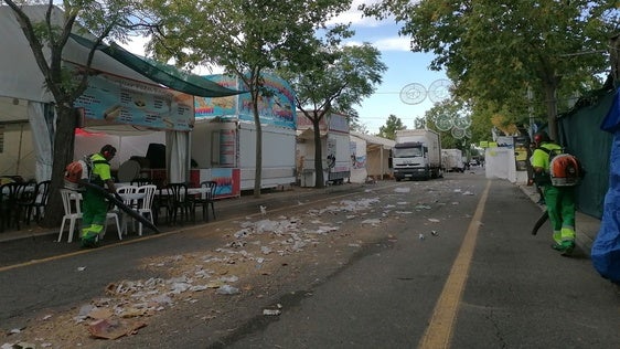 Dos operarios limpian las calles del ferial