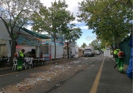 Dos operarios limpian las calles del ferial