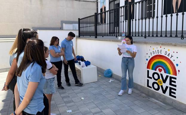 Lectura del manifiesto con el mural de fondo 