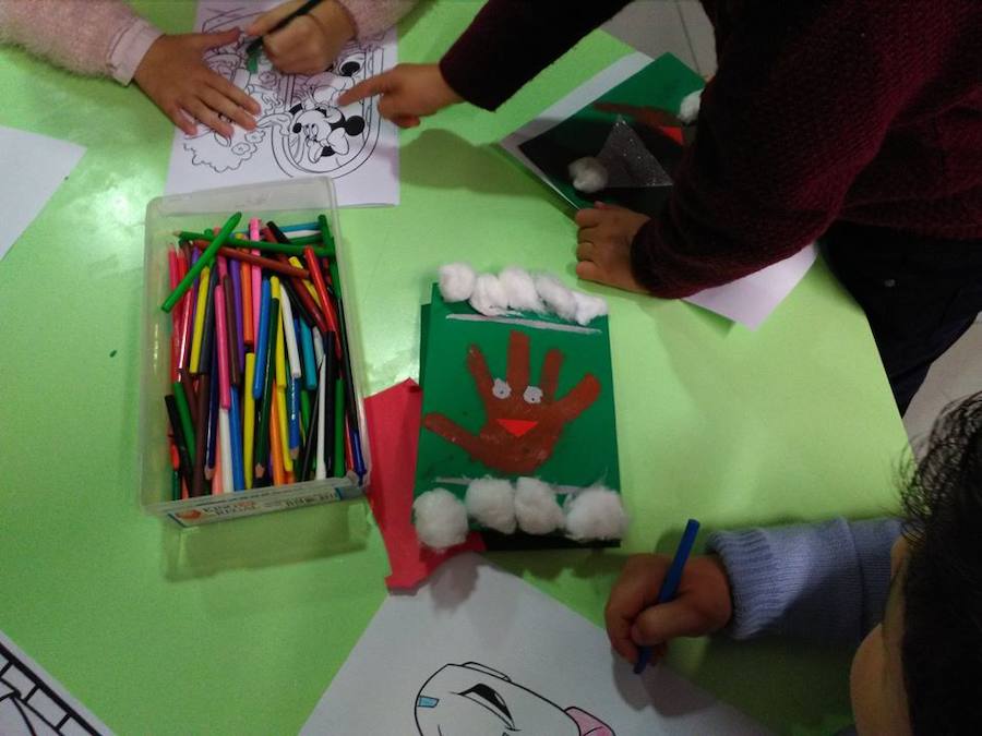 Los niños realizando postales navideñas  