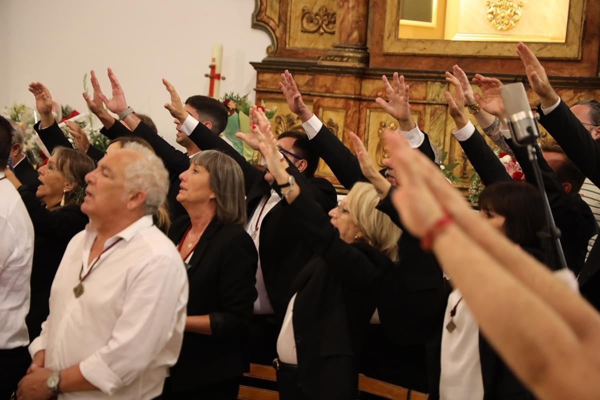 Los devotos alzan los brazos en señal de alabanza.