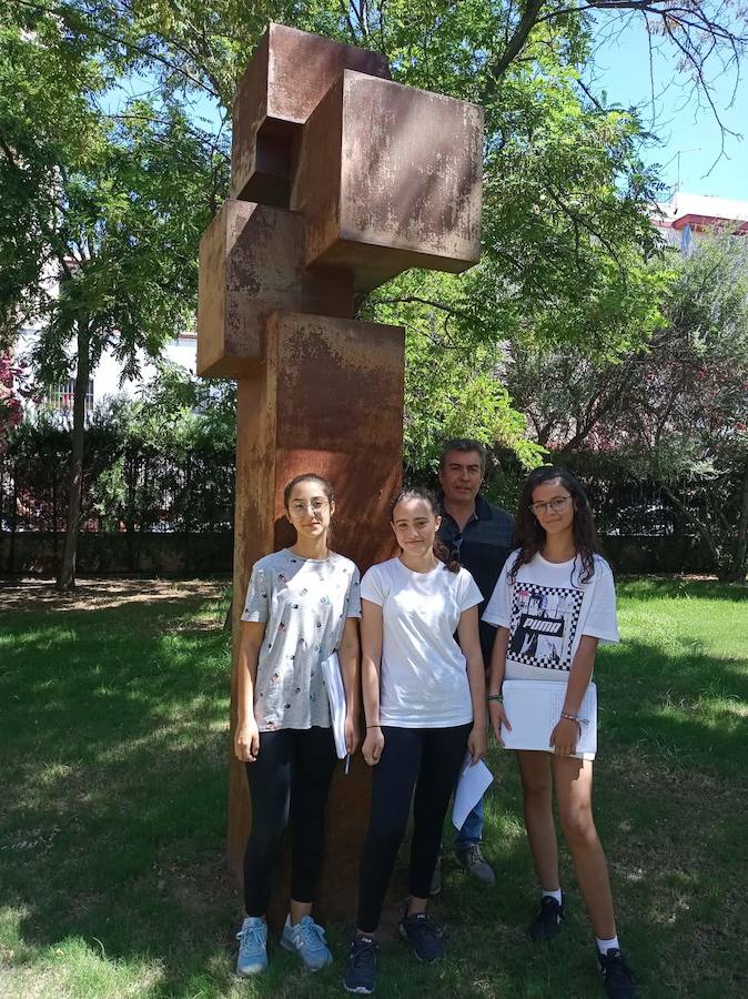 Las tres jóvenes posan con el profesor. 