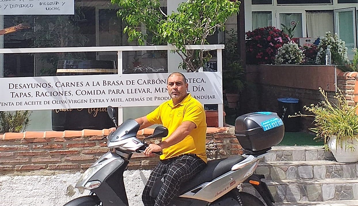 Miguel Ángel Maldonado, con su moto, se dispone a realizar un reparto. 