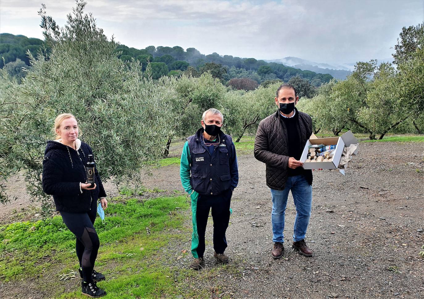 Rosario, Salvador y Félix en la finca de olivares con el marco de la sierra como fondo. 