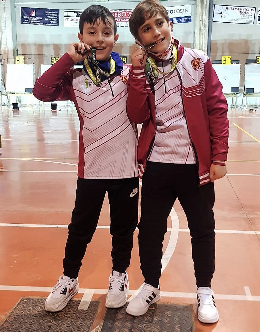 Hugo Vico y Antonio Toribio muerden sus medallas. 