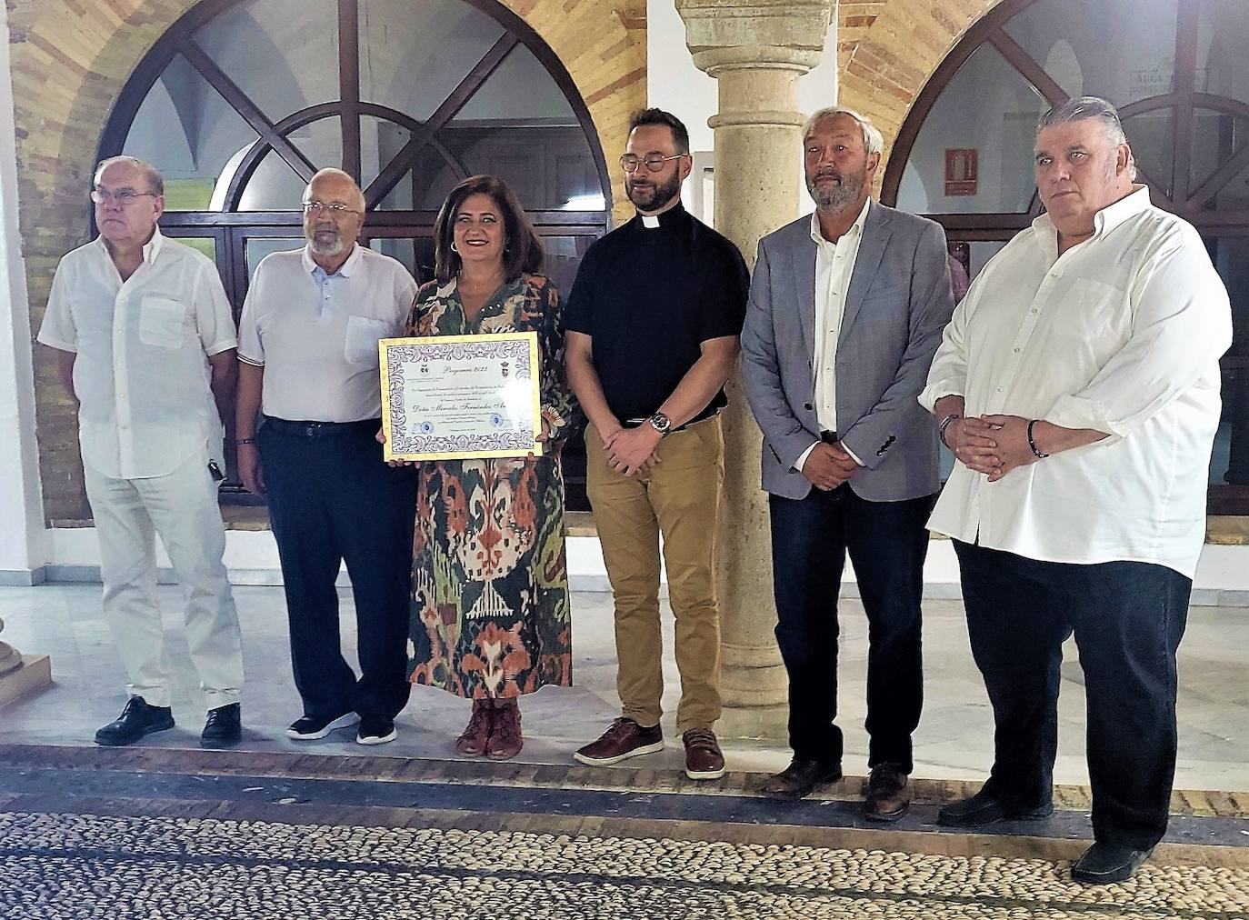 Mercedes Fernández, con la placa acreditativa, junto con los representantes del Ayuntamiento y la Agrupación de Cofradías. 
