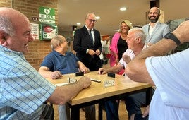 Estrella contempla una partida de dominó.