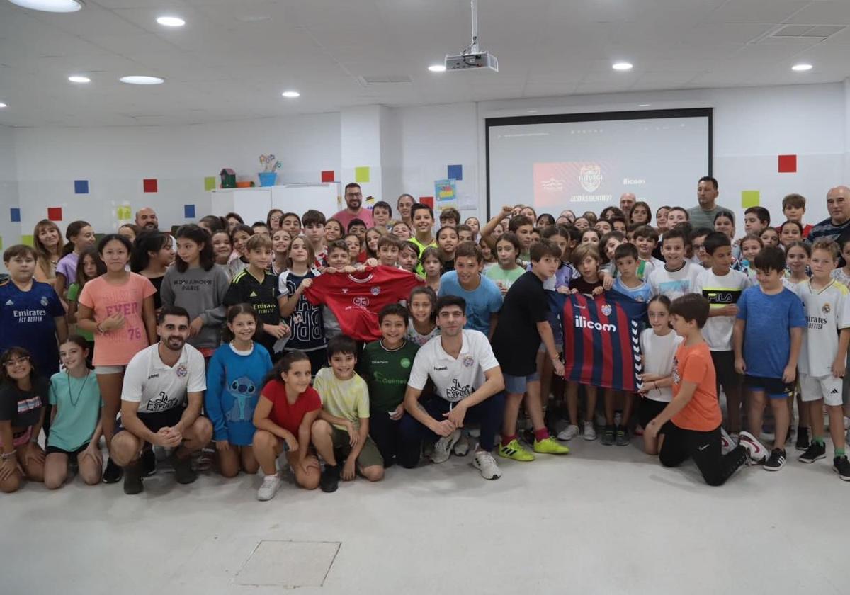 Escolares del colegio Capitán Cortés con los futbolistas y directivos del equipo.