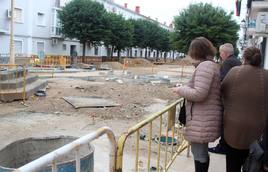 Vecinos contemplan tras las vallas como han quedado las obras.