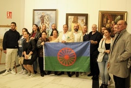 Participantes del acto portan la bandera del pueblo gitano.