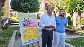 El alcalde, y el técnico responsable de la campaña, posan en la calle con el cartel.
