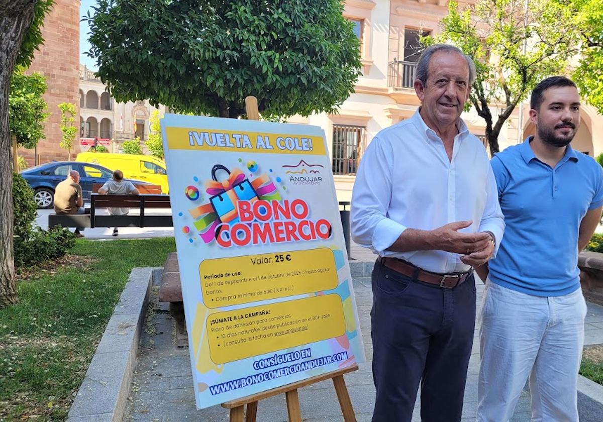 El alcalde, y el técnico responsable de la campaña, posan en la calle con el cartel.