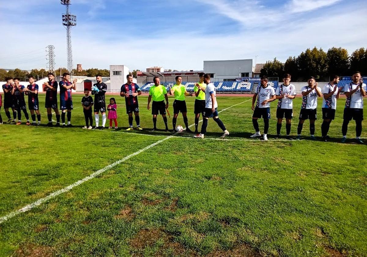 SALUDO DE AMBOS EQUIPOS DONDE SE PUEDE VER EL MAL ESTADO DEL TERRENO DE JUEGO.
