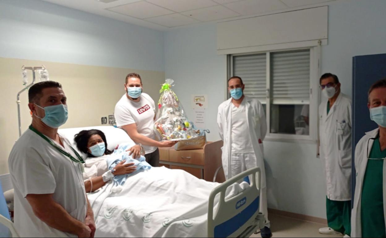 Jomás en brazos de su madre, junto a su padre y el equipo medico del Hospital de Baza que le atendió. 