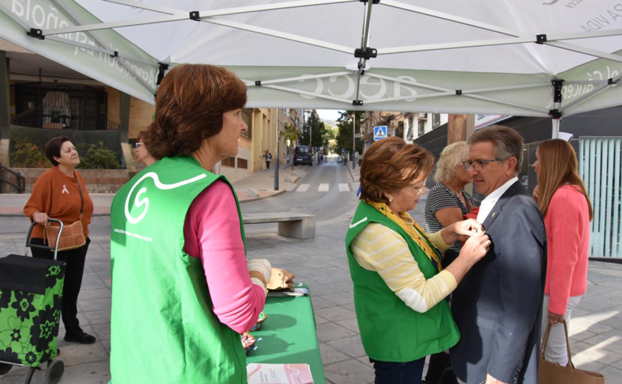 Una voluntaria pone un laso rosa al Alcalde de Baza 