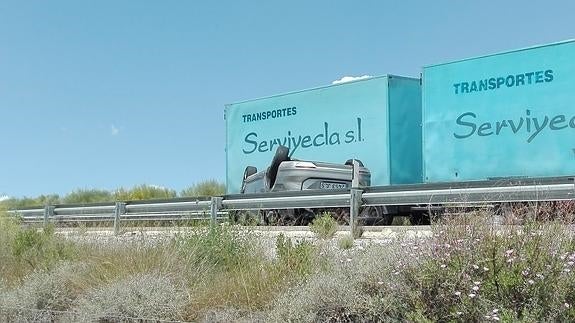 Uno de los vehículos implicados en el accidente, volcado en la autovía 